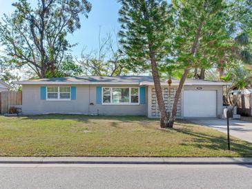 Gray house with teal accents, landscaped lawn, and attached garage at 4666 86Th N Ave, Pinellas Park, FL 33782