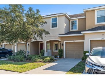Two-story townhome with attached garage and landscaped front yard at 6944 Towne Lake Rd, Riverview, FL 33578