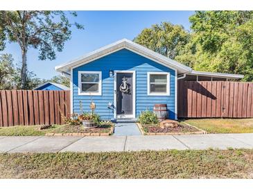 Charming blue house with wooden fence and landscaping at 14045 21St St, Dade City, FL 33525