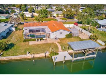 Waterfront property featuring a pool, dock, and scenic canal views, perfect for outdoor living at 1575 Brookside Blvd, Largo, FL 33770