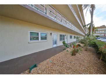 Exterior view of condo building showcasing landscaping and building features at 5725 80Th N St # 116, St Petersburg, FL 33709