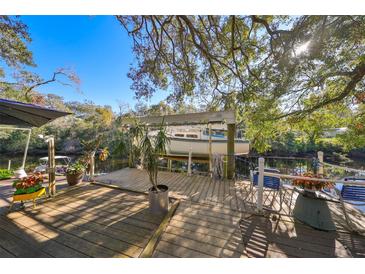 Waterfront dock with boat lift and shaded seating area at 1745 E Mulberry Dr, Tampa, FL 33604