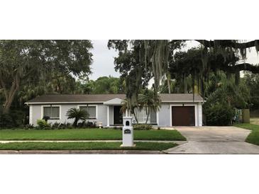 Single-story home with gray exterior, attached garage, and landscaped lawn at 4820 W San Jose St, Tampa, FL 33629