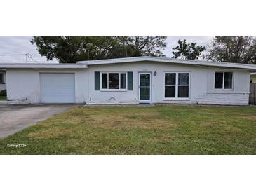 Ranch-style home with attached garage and well-maintained lawn at 1413 Lemon St, Clearwater, FL 33756