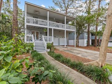 Two-story house with wrap-around porch, driveway, and landscaped yard at 514 Wideview Ave, Tarpon Springs, FL 34689