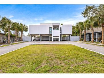 Modern two-story home with a carport and manicured lawn at 6 Treasure Ln, Treasure Island, FL 33706