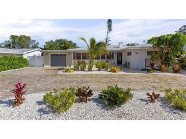 House exterior featuring a large driveway and well-manicured landscaping at 1217 De Narvaez Ave, Bradenton, FL 34209