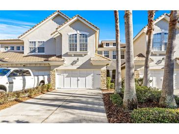 Inviting exterior of a two-story townhome with a two-car garage and palm trees at 14545 Mirabelle Vista Cir, Tampa, FL 33626