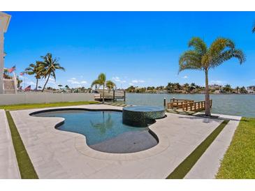 Luxury pool with mosaic tile accents, surrounded by a spacious patio and lush landscaping at 17059 Dolphin Dr, North Redington Beach, FL 33708