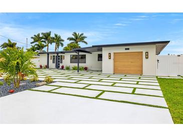 Modern home showcasing a paver driveway with turf accents and lush landscaping at 407 41St Ave, St Pete Beach, FL 33706
