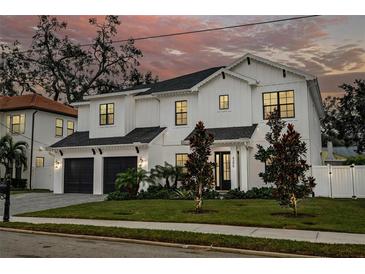 Stunning two-story home with a white exterior, dark accents, and a manicured lawn at 4306 W Barcelona St, Tampa, FL 33629