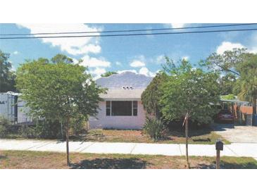 Charming single-story home with lush landscaping, a covered carport, and a well-maintained front yard at 509 Rosery Nw Rd, Largo, FL 33770