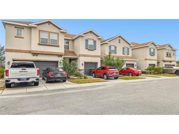 Tan townhouses with gray garage doors and blue shutters at 8126 Muddy Pines Pl, Tampa, FL 33635