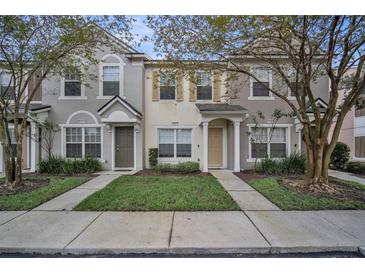 Two-story townhome with gray exterior, two-car driveway, and landscaping at 10157 Bessemer Pond Ct, Riverview, FL 33578