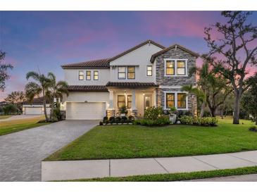 Two-story house with stone accents and a landscaped yard at 7876 Marsh Pointe Dr, Tampa, FL 33635