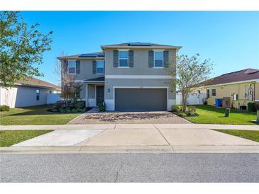 Two-story house with gray siding, solar panels, and a two-car garage at 11514 Brighton Knoll Loop, Riverview, FL 33579