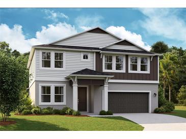 Two-story home with gray and brown exterior, two-car garage, and landscaped lawn at 12140 Cattleside Dr, Riverview, FL 33579