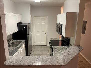 Modern kitchen with granite countertops and stainless steel appliances at 18001 Richmond Place Dr # 125, Tampa, FL 33647