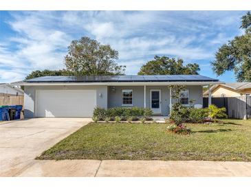 Newly renovated home with solar panels and a well-manicured lawn at 3116 Winchester Dr, Dunedin, FL 34698