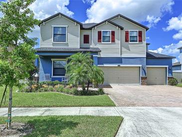 Two-story house with a two-car garage and landscaped yard at 2999 Hilliard Dr, Wesley Chapel, FL 33543