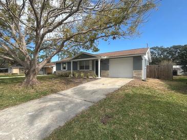 Newly renovated home with gray exterior, stone accents, and a spacious driveway at 7318 Dianne Dr, New Port Richey, FL 34652