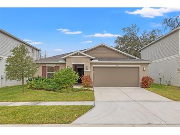 Single-story home with attached garage and well-maintained lawn at 3946 Postmark Lake Pl, Seffner, FL 33584