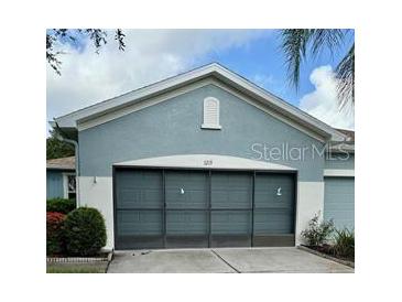 House exterior featuring a two-car garage and well-manicured landscaping at 1213 Huntington Greens Dr, Sun City Center, FL 33573