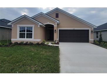 One-story house with brown garage door and neutral exterior at 13278 Ogden Glade Rd, Dade City, FL 33525
