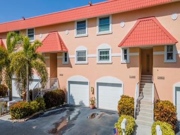 Attractive two-story condo with red tile roofs, attached garages, and landscaped grounds at 12482 Capri N Cir # 4, Treasure Island, FL 33706