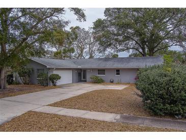 Ranch style home with attached garage and mature landscaping at 1566 Long St, Clearwater, FL 33755