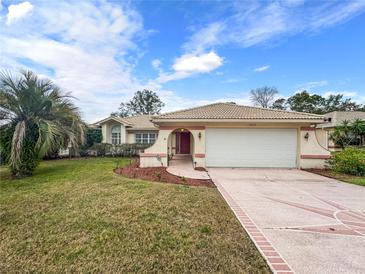 Single-story house with a two-car garage and manicured lawn at 10454 Ventura Dr, Spring Hill, FL 34608