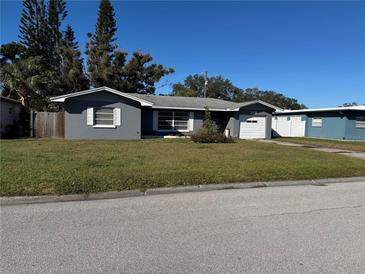 Ranch-style home with gray exterior, attached garage, and well-maintained lawn at 10 N Neptune Ave, Clearwater, FL 33765