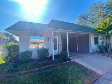 Front view of a single-story house with carport at 889 Sky Loch S Dr, Dunedin, FL 34698