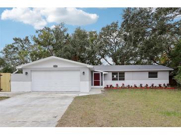 Newly renovated home with gray and white exterior, landscaped yard, and a two-car garage at 11592 110Th Ter, Seminole, FL 33778