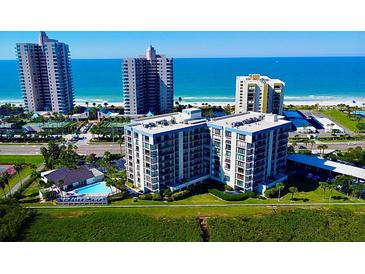 Aerial view of a condo building near the beach, with a pool and tennis courts at 1501 Gulf Blvd # 104, Clearwater Beach, FL 33767