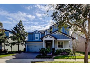 Two-story home with gray siding, a large driveway, and landscaped yard at 2670 Whittler Br, Odessa, FL 33556