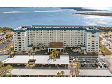 Aerial view of a waterfront condo building with parking and beautiful water views at 7 Elgin Pl # 208, Dunedin, FL 34698