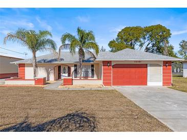 Single-story home with attached garage and palm trees at 13101 Delbarton St, Spring Hill, FL 34609
