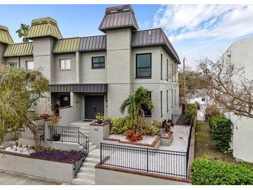 Gray two-story home with landscaped front yard and black metal fence at 162 E Davis Blvd, Tampa, FL 33606