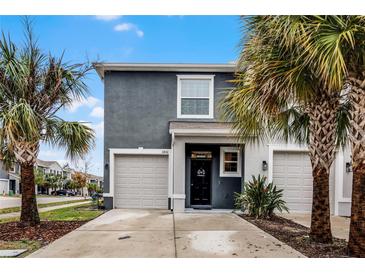 Two-story townhome with gray exterior, two-car garage, and palm trees at 3830 Vignoble Ln, Brandon, FL 33511