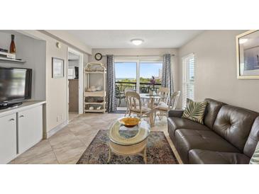 Bright living room with ocean view, leather sofa, and dining area at 4510 Gulf Blvd # 408, St Pete Beach, FL 33706