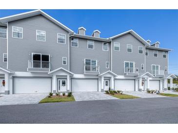 Modern gray townhouses with white garages and landscaping at 5736 Biscayne Ct # 3, New Port Richey, FL 34652