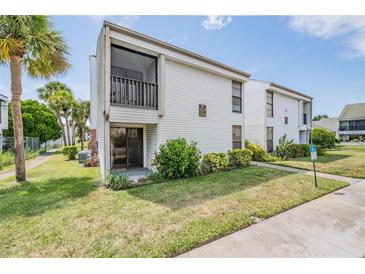 Two-story building exterior, featuring white siding and a balcony at 706 Haven Pl, Tarpon Springs, FL 34689