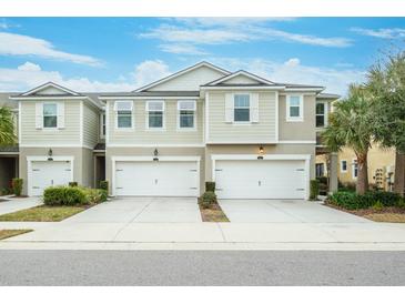 Two-story townhome with attached two-car garage, landscaping, and neutral color palette at 1815 Sunset Wind Loop # 118, Oldsmar, FL 34677
