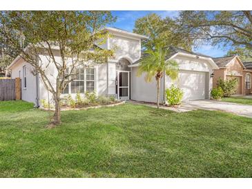House exterior featuring a well-maintained lawn and a two-car garage at 5301 Watson Rd, Riverview, FL 33578