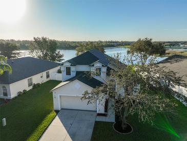 Two-story house with lake view, driveway, and landscaped lawn at 8111 Tar Hollow Dr, Gibsonton, FL 33534