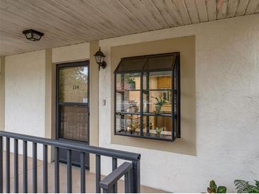 Exterior view of condo building, showing entrance with a window and a small balcony at 11511 113Th St # 13H, Largo, FL 33778