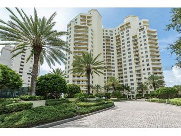 Luxury high-rise building with palm trees and landscaped grounds at 1200 Gulf Blvd # 204, Clearwater Beach, FL 33767