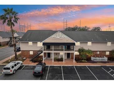 Two-story building exterior at sunset, featuring parking and landscaping at 200 Country Club Dr # 802, Largo, FL 33771