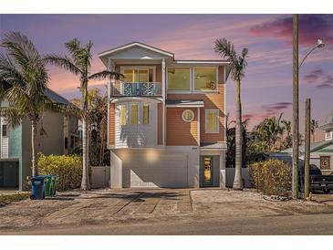 Charming three-story coastal home featuring a balcony, rounded windows, and a garage at 206 Church Ave, Bradenton Beach, FL 34217